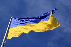 Ukraine flag large national symbol fluttering in blue sky. Large yellow blue Ukrainian state flag, Dnipro city, Independence Constitution Day, National holiday. 
