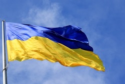 Flag of Ukraine flutters in blue sky. Large yellow  blue Ukrainian national state flag, city Kyiv Ukraine