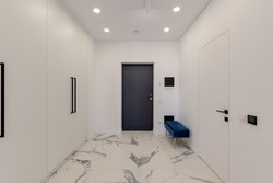 Wide angle view of the entrance to the apartment with white interior and marble floor. High quality photo