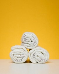 Twisted white rags for mopping on a yellow background