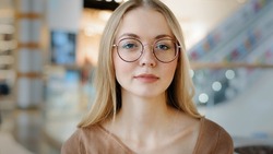 Close up headshot portrait indoors calm Caucasian woman in eyeglasses lady girl blonde female in glasses indoors posing looking at camera businesswoman worker student model company CEO employer boss