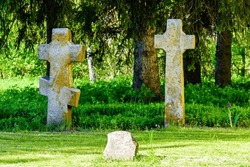 Old stone crosses at ancient cemetery. Abandoned graveyard