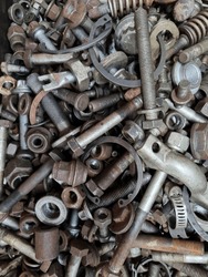 Metal objects in a car repair shop, scrap. Old bolts, screws, nuts. Spare parts. Texture. Selective focus