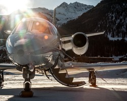 Parked at Samedan Engadin Airport over snow park at the last light of day. Private bizjet airplane used by businessmen, VIP and rich people to move around the world.