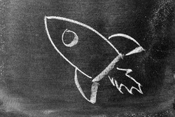 White color chalk hand drawing in rocket shape on blackboard or chalkboard background (Concept for new experience, start up the business)