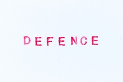 Red color ink rubber stamp in word defence on white paper background