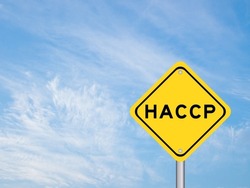 Yellow transportation sign with word HACCP (Hazard Analysis Critical Control Points) on blue color sky background