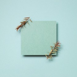 Blue blank memo paper with dry leaf on blue background. top view, copy space