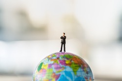 Global and Business Concept. Businessman miniature people figure standing on mini world ball model.