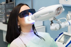 Teeth whitening for woman. Bleaching of the teeth at dentist clinic. 