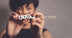 Stop asian hate hashtag, support Asian americans communities, stop hate crimes campaign. A beautiful Asian woman hold letter word 