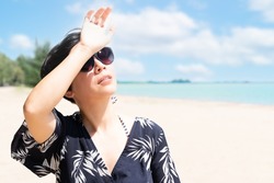A beautiful stylish asian woman on the beach wearing 100% UV sunglasses to protect her eyes and face from sun exposure. Skin aging, Optical, Ultraviolet keratitis, Skincare, SPF, Beauty, Copy space.