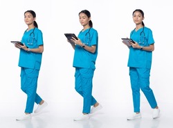 Full length 20s young Asian Woman clinic Nurse, walking forward left right, wear blue dress pants shoes stethoscope. Smile Hospital female hold patient chart over white background isolated