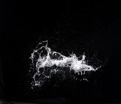 Water splash in air drop over black background, studio lighting high speed. water splashing throw in wind air and freeze stop with flash to see droplet texture for filter and layer