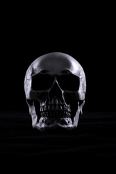 Halloween human skull on an old wooden table over black background. Shape of skull bone for Death head on halloween festival which show horror evil tooth fear and scary, copy space