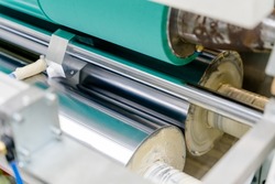 The dry lamination machine uses a rubber cylinder to glue adhesive to a flexible film. This is one of the processes in the packaging business.