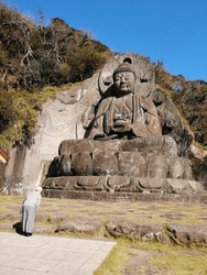 Japanese old lady praying the big Buddha statue at Mount Nokogiri