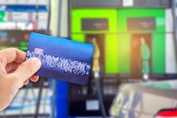 Man use credit card with blur image of gas station as background.(concept don't use mobile in gas station)