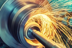 Internal grinding of a cylindrical part with an abrasive wheel on a machine, sparks fly in different directions. Metal machining.