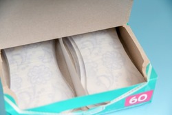 Sanitary pads for women in the package on a blue background.