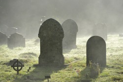 Misty graveyard,crosses and graves backlit