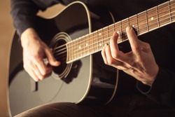 guitarist playing acoustic guitar close-up shot 