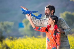 Rural indian girl playing with father in agriculture field.