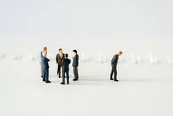 Miniature people A depressed Businessman mini figures standing out of group thinking on white background using as Success Business partnership development and Commerce Strategy Planning concepts