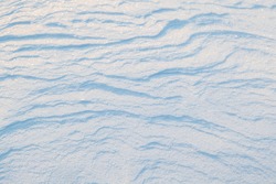 The structural texture of the snow. Winter snowy abstract background. Selective focus.