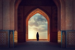 Silhouette of a Persian woman in national dress against the background of traditional Iranian architecture. Sunset. Iran. Kashan.