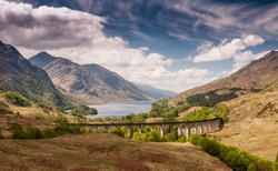 The Glenfinnan Viaduct carries the West Highland Railway Line high above Glen Finnan valley beside the lochs and mountains of Scotland.