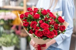 bouquet in the hands of a cute girl. garden red spray roses. Color passionately scarlet, Autumn mood
