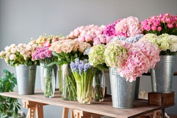 Many different colors on the stand or wooden table in the flower shop. Showcase. Background of mix of flowers. Beautiful flowers for catalog or online store. Floral shop and delivery concept. Top view