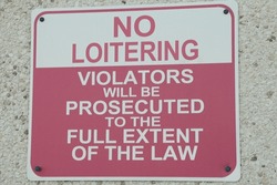 no loitering violators will be prosecuted to the full extent of the law writing caption text sign on wall, white and red