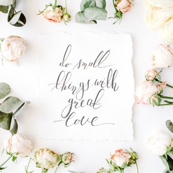 inspirational quote do small things with great love written in calligraphy style on paper with pink roses and eucalyptus branches on white background. flat lay, top view