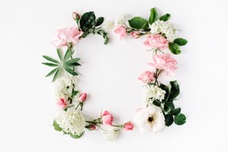 flat lay frame with pink and white roses, branches, leaves and petals isolated on white background. top view