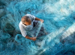 Old Fishermen are repairing fishing nets.Fishermen are cleaning fishing nets.Thailand