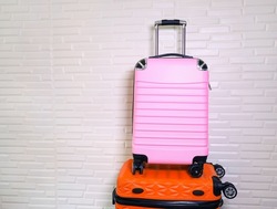 Pile of  pink colors and orange colors different  the luggage on white wall background. travel concept