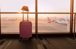 Travel concept with Pink luggage as hat in the airport terminal waiting area, summer vacation concept, traveling and enjoying concept