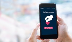 e-donation concept.close-up of man hands make an online donate via mobile phone