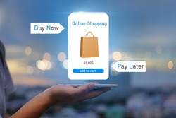 BNPL Buy now pay later online shopping concept.Hands holding mobile phone on blurred city as background