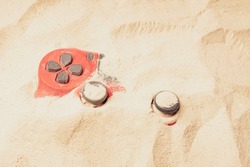 sand and gamepad, red gamepad buried in the sand. buried gaming device