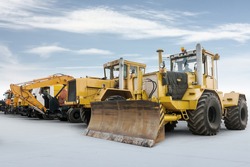 Two heavy wheeled tractor one excavator and other construction machinery isolated on bright background