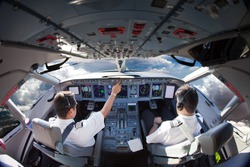 Flight Deck of modern aircraft. Pilots at work. Clouds view from the plane cockpit.