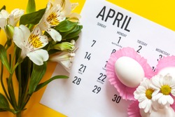April 2020 calendar, cute pure white easter eggs and white flowers on yellow background. April 2020 monthly calendar. Top view. View from above. Monthly April calendar