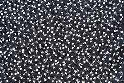 Vintage floral background. Floral pattern with small white flowers on a black background. 