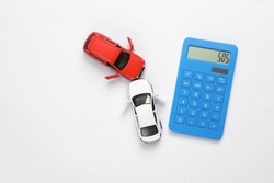 Two mini toy car crash with calculator on white background, incident, car traffic accident. Top view