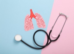 Paper-cut anatomical human lungs with a stethoscope on a blue-pink pastel background. Diagnosis of pulmonary diseases. Top view
