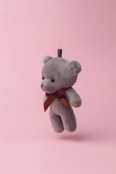 Teddy bear flying in antigravity on pink background with shadow. Levitation object in the air. Creative minimal layout