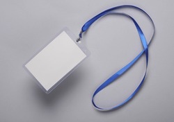 Empty white ID card badge mockup with blue belt on gray background. Staff identity name tag. Space for text and design. Top view. Flat lay
